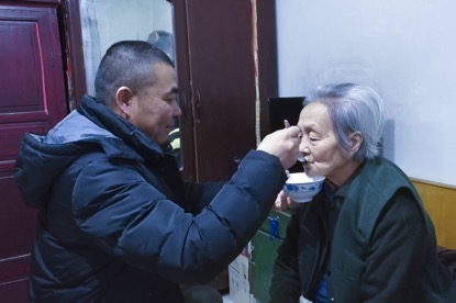 崔金鎖給84歲老母親喂飯 （譚永良 攝）